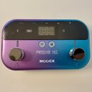 Multiefektový pedál v kovovém provedení s barevným přechodem od fialové k modré. Na horní straně je černý displej s ikonami baterie a Bluetooth, pod…