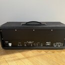 Zadní strana kytarového zesilovače v černém texturovaném potahu s kovovými rohy a rukojetí. Na zadním panelu je nápis ENGL a označení modelu Poweramp…