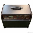 Zadní strana hnědého komba s černým koženým úchem na horní straně. Na zadním panelu je bílý štítek s nápisy Roland, MODEL AC-60, 50 W a sériovým čísl…