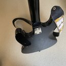 Zadní strana černé elektrické kytary s černým popruhem, na kterém je žlutý nápis Fender. V místě spoje krku s tělem je vidět kovová destička připevně…