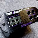 Černý dvoukanálový DI box s kovovým broušeným povrchem. Na horní straně je bílý a fialový nápis DUALZ Direct a Dual Channel Passive Direct Box, v dol…