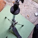Stříbrný kovový stativ s černým pěnovým prstencem a černou nožní pedálem. Na pedálu je viditelné logo značky Yamaha. Stav povrchu působí užitě, s mír…
