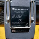Zadní strana černého bezdrátového přijímače s kovovým klipem. Na štítku je uveden nápis SENNHEISER BODYPACK RECEIVER EK 100 G2 C, FREQ RANGE: 740-776…