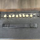 Horní ovládací panel kytarového komba v černé barvě s bílými plastovými knoflíky. Na panelu jsou nápisy CLEAN, OVERDRIVE, EQUALISATION a REVERB, dále…