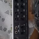 Zadní strana bílého audio rozhraní s různými konektory. Jsou zde nápisy MIC/LINE/HI-Z, LINE INPUT, LINE OUTPUT, PHONES, S/PDIF, USB 2.0 a 2TR IN. V h…