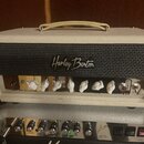 Dva kytarové zesilovače v béžovém potahu. Horní přístroj má černou mřížku s bílým nápisem Harley Benton a ovládací knoflíky v krémové barvě, vedle ni…