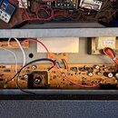 Fotografie zachycuje vnitřek elektronického zařízení s odkrytými plošnými spoji a komponenty. Na jedné z desek je viditelný nápis LC-B0 V1. V horní č…