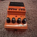 Oranžový kytarový efekt s nápisem HOT HEAD DISTORTION a logem DigiTech. Na horní části je černý gumový nárazník. Přístroj má čtyři černé ovládací kno…