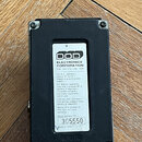 Zadní strana černého kytarového efektpedálu s bílou nálepkou. Na nálepce je logo DOD a nápis ELECTRONICS CORPORATION, Sal Lake City, Utah USA. Dole j…