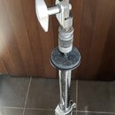 Detail chromovaného stojanu s kovovým šroubem a knoflíkem. Na stojanu je nasazeno šedé plstěné podložky v různých tvarech. V dolní části je viditelný…