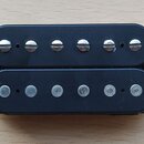Černý humbucker s dvěma řadami šesti snímačů. Horní řada má viditelné šroubovací hlavy, spodní řada jsou hladké čepy. Na komponentu nejsou viditelné…