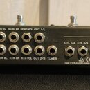 Zadní strana černého elektronického zařízení s řadou konektorů. Jsou zde nápisy Roland Corporation, MADE IN TAIWAN a MODEL: ES-8 s sériovým číslem A4…