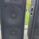 Dvě černé reproduktorové bedny s kovovou mřížkou. Na spodní části předního panelu je oranžovo-bílé logo JBL a pod ním nápis JBL Professional. Povrch…