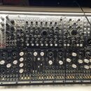 Fotografie zachycuje modulární syntetizátor v racku. Horní řada obsahuje moduly s nápisy Endorphine, COSMOTRONIC, Queen Of Pentacles a BLACK JOYSTICK…