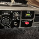 Detailní záběr na přední panel stříbrného rackového zařízení značky BEHRINGER. Viditelný je vstupní kanál označený číslem 8 s konektory MIC IN (XLR)…