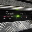 Černý rackový přístroj s nápisem the t.racks a označením modelu VM-100. Na předním panelu je řada kontrolních LED diod s dopisovými hodnotami 190, 20…
