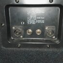 Detail zadní strany reproduktorové skříně s černým povrchem. Jsou zde dva konektory pro připojení kabelů a nápis: ONLY USE LOUDSPEAKER CABLES FOR CON…