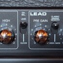 Detailní pohled na ovládací panel kytarového zesilovače. Panel obsahuje sekce INPUTS s přepínačem HIGH GAIN a LOW GAIN, CLEAN s ovládání VOLUME, LOW,…