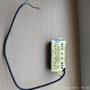 Zlatý humbucker s kovovým krytem a připojeným černým kabelem. Na zadní straně je bílá nálepka s nápisem DF192FBKU 586073 a vyražený text SEAGULL PICK…