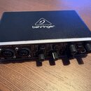 Černý audio interface s kovovým šasi a stříbrným horním okrajem. Na horní straně je bílé logo behringer a na předním panelu nápis U-PHORIA UMC204HD.…