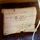 Fotografie detailu štítku uvnitř akustického nástroje. Na štítku je uveden nápis modello RANGER 12 ELECTRA a logo EKO Guitars. Dole je text Chitarra…