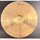 Kruhová mosazná činely v zlatavé barvě s viditelným broušením povrchu. V horní části je černé logo „Cream“ a pod ním menší nápis „Cymbals and Gongs“.…