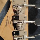 Zadní strana hlavy světle dřevěné kytary s четыma chromovanými ladičkami. Na dřevě je černý nápis Fender, Crafted in Indonesia a s/n ic081054828. Pov…