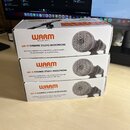 Tři identické bílé krabice naskládané na sebe. Na každé krabici je oranžovo-černé logo WARM AUDIO a nápis WA-19 DYNAMIC STUDIO MICROPHONE. Pod tímto…