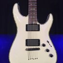 Bílá elektrická kytara s perleťovým lemováním kolem těla. Nástroj má dva černé humbuckery s nápisem emg a tři černé ovládací knoflíky. Na hřebenku je…