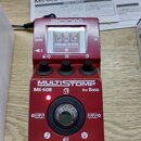 Červený efektový pedál s nápisy ZOOM a MULTISTOMP MS-60B for Bass. Zařízení má digitální displej, na kterém je vidět text DYNAMIC REVERB a tři ovláda…