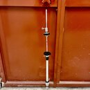 Stříbrný kovový stojan s černými plastovými prvky a rozkládacím základním stativem. Stojan má teleskopickou konstrukci s několika regulačními knoflík…