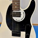 Bílá elektrická kytara s černým plechtrátem a hnědým hmatníkem. Na bílém krytu snímače je černý nápis Fender Monocaster. Kytara má jeden snímač typu…