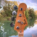 Záběr na hlavu dřevěné basové kytary s nápisem Fender® JAZZ BASS a menším textem MADE IN USA. Pod logem je svisle napsáno serial 7631170. Nástroj má…