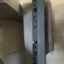 Zadní strana šedého elektronického zařízení s několika konektory. Na panelu jsou viditelné nápisy: "MIC IN", "TAPE/AUXILIARY SELECT", "LINE OUT", "ST…