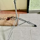 Stříbrný kovový stativ s rozkládacím trojnohým základnami a černými gumovými koncovkami. Na fotce nejsou viditelné žádné značky, loga ani nápisy. Pov…