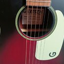 Detail akustické kytary s červeně-černým přechodem (sunburst) a krémovým plechtrem s logem G. Uvnitř otvoru je štítek s nápisy GRETSCH ROOTS COLLECTI…