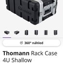 Černý transportní rack case s hliníkovými hranami a kovovými zámky. Na boku je vyražen nápis thomann. V přední části je vidět montážní lišta pro rack…