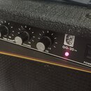 Černý kytarový kombo zesilovač s texturovaným povrchem. Na ovládacím panelu jsou tři černé otočné knoflíky s popisky TUBE STACK®, VOLUME a EQ, červen…