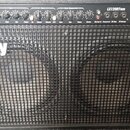 Černý kytarový kombo zesilovač značky Laney s dvěma reproduktory za kovovou mřížkou. Na horním ovládacím panelu je nápis LX120RTWIN a řada ovládacích…
