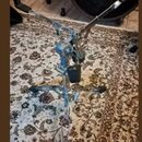 Fotografie zobrazuje chromovaný stojan na bicí nástroj, pravděpodobně činely nebo perkuse. Stojan má rozkládací trojnožku s gumovými koncovkami a nas…