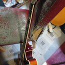 Kytara s červeným lakem a hnědým stupňováním na hranách těla. Na hmatníku jsou viditelné pražce a v horní části krku je nápis "Gibson". Nástroj je op…
