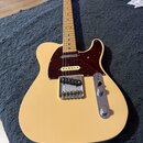 Kytara typu Telecaster v krémové barvě s hnědým pickguardem a javorovým hmatníkem. Na hlavě je viditelné logo Fender. Nástroj má dva snímače, kovový…