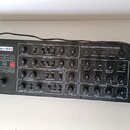 Černý analogový syntetizátor s nápisy Pro-800 a behringer. Přístroj obsahuje početné otočné knoflíky, tlačítka s čísly 0–9 a různé ovládací sekce jak…