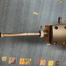 Detailní pohled na hnedo-žlutý nástroj s kovovým, stříbrným extendrem. Na černé části těla jsou vidět čtyři otvory pro šrouby. Povrch kovových částí…