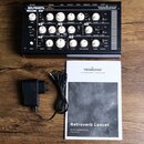 Černý efektový pedal s nápisy Retroverb lancet a VERMONA. Zařízení obsahuje množství bílých otočných knoflíků, přepínačů a konektorů na horním a zadn…