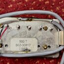 Fotografie zachycuje zadní stranu kovového elektronického modulu s připojenými šedými kabely. Na povrchu je vidět nápis „usd leath“ a nálepka s texte…