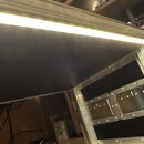 Detail vnitřku transportního kufru s hliníkovými profily a kovovými rohy. V horní části je integrovaný svítící LED pásek. V pravé části jsou vidět ko…