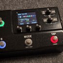 Černý kytarový efekt s displejem a ovládacími prvky. Na displeji je vidět text „02A Torn SC“ a „Kinky Comp“ s parametry Sens 5.0, Mix 100% a Attack 0…