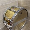 Žlutý buben s kovovým obručováním a chromovaným kováním. Na straně je vidět nápis YAMAHA a na obruči text POWER HOOP. Povrch bubnu vykazuje drobné ne…