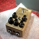 Zlatý kytarový efekt s nápisem TOMNUS DELUXE a logem Warm Audio. Na horní straně se nachází pět černých otočných knoflíků, jeden přepínací spínač a s…